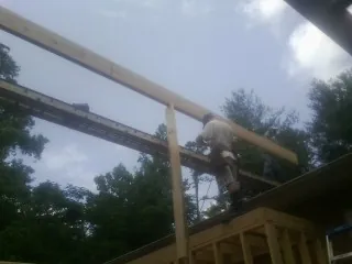 Carpenter setting a ridge beam over a new addition frame — Ice Dam Removal by Roofing Brothers in Selmer