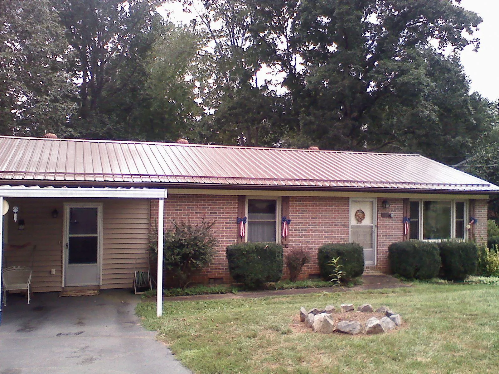 Bronze metal roof and carport on a brick ranch home — Roof Repair work by our crew in Selmer